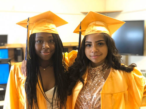 two female students in cap and gown